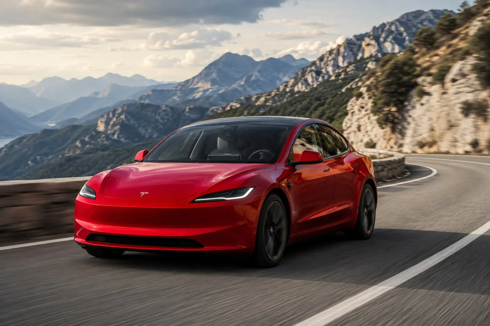 Tesla Model 3 rojo circulando por una carretera de montaña